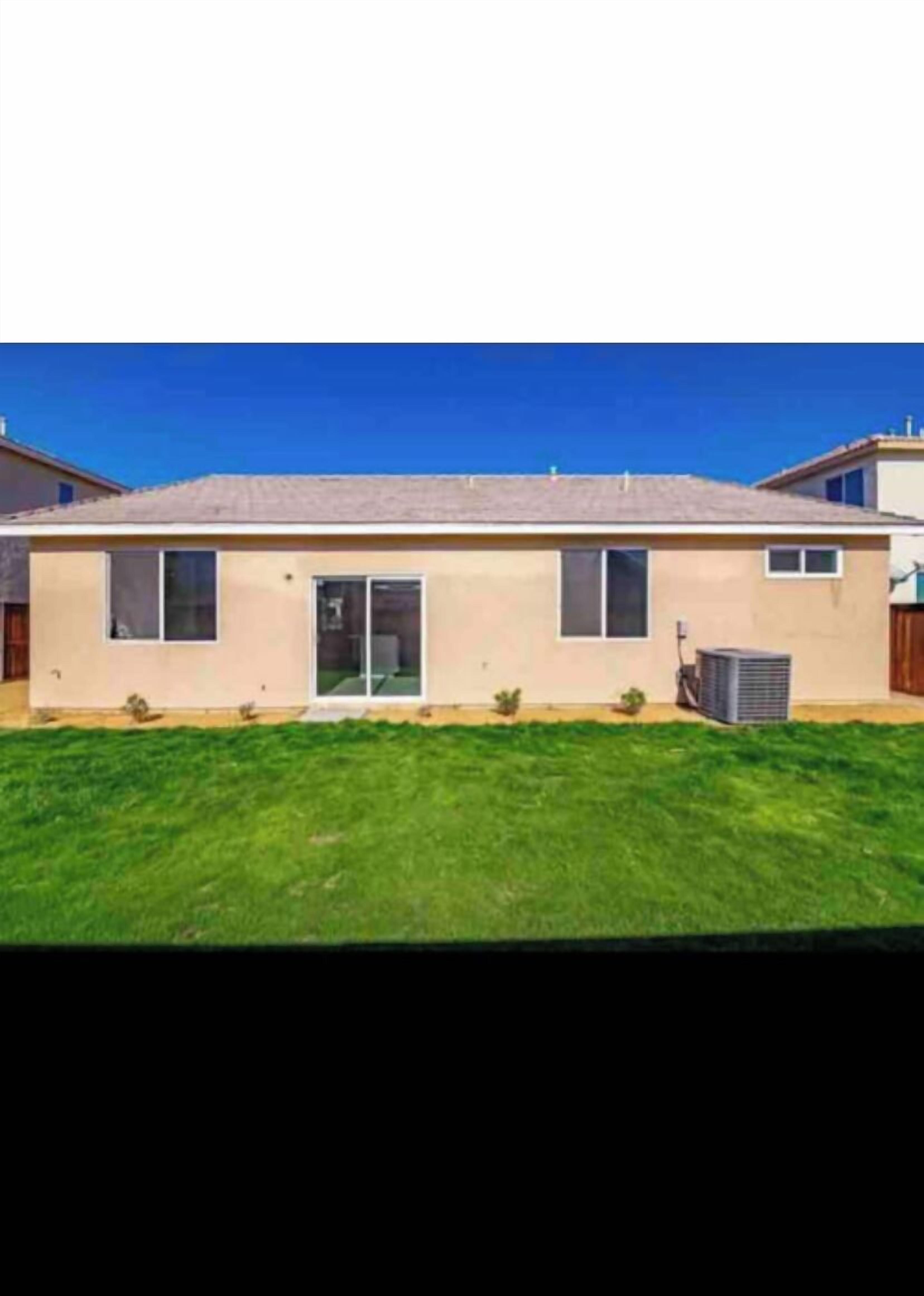 A single-story house with a flat roof, a front door, and a small front yard.