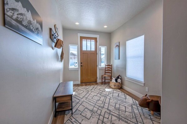 A hallway with a wooden bench, a rug, a chair, and a small statue. - 3BR Rellerstone Bunkhouse w/AC Fall Special - buy 5 nights, get 2 free Sept. - Nov (Victor)