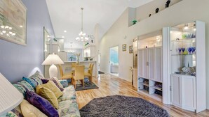A spacious living room with a sofa, a dining area, and a kitchen. - Active Gated Golf Community! Pool, Spa, Fitness, Tennis, Close To Shopping & Short Drive to Beaches! (Estero)