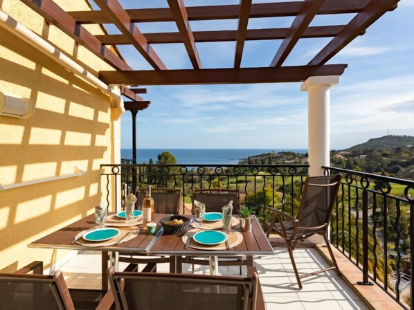 Terraço com mesa posta para dois, com vista para uma paisagem deslumbrante.
