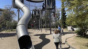A playground with a slide, climbing structures, and a netted area.