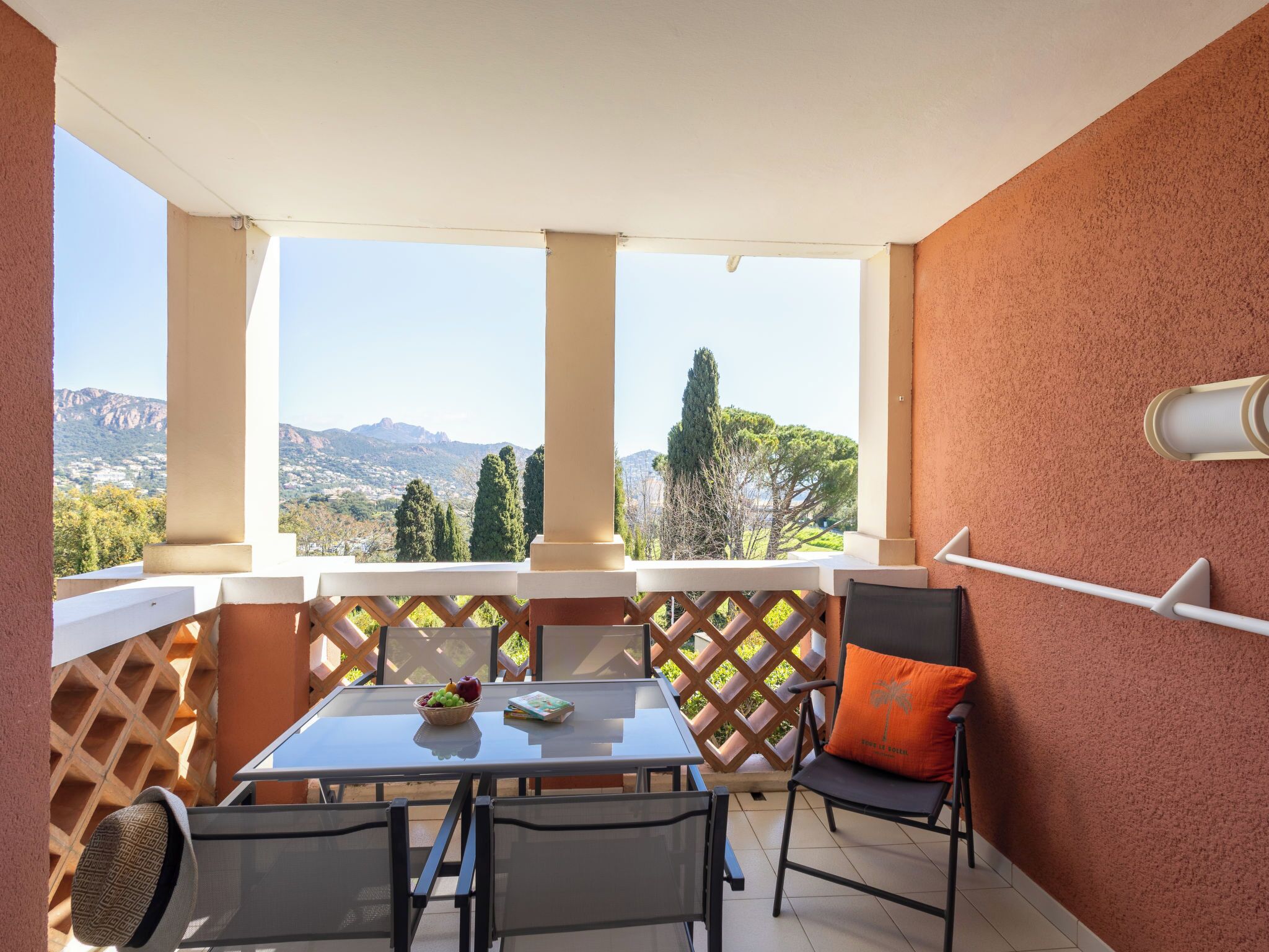 A balcony with a table, chairs, and a view of the landscape.