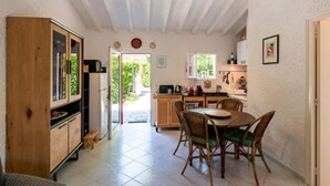A compact kitchen with a dining area, wooden cabinets, and a view to the outside. - Villa Irène by Interhome (Bravone)