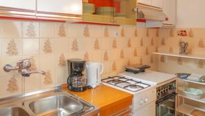 A kitchen with a gas stove, a coffee maker, and a sink. - Apartment Nena by Interhome (Sveti Juraj)
