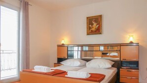 A hotel room with a bed, a nightstand, a mirror, and a painting on the wall. - Apartment Nena by Interhome (Sveti Juraj)