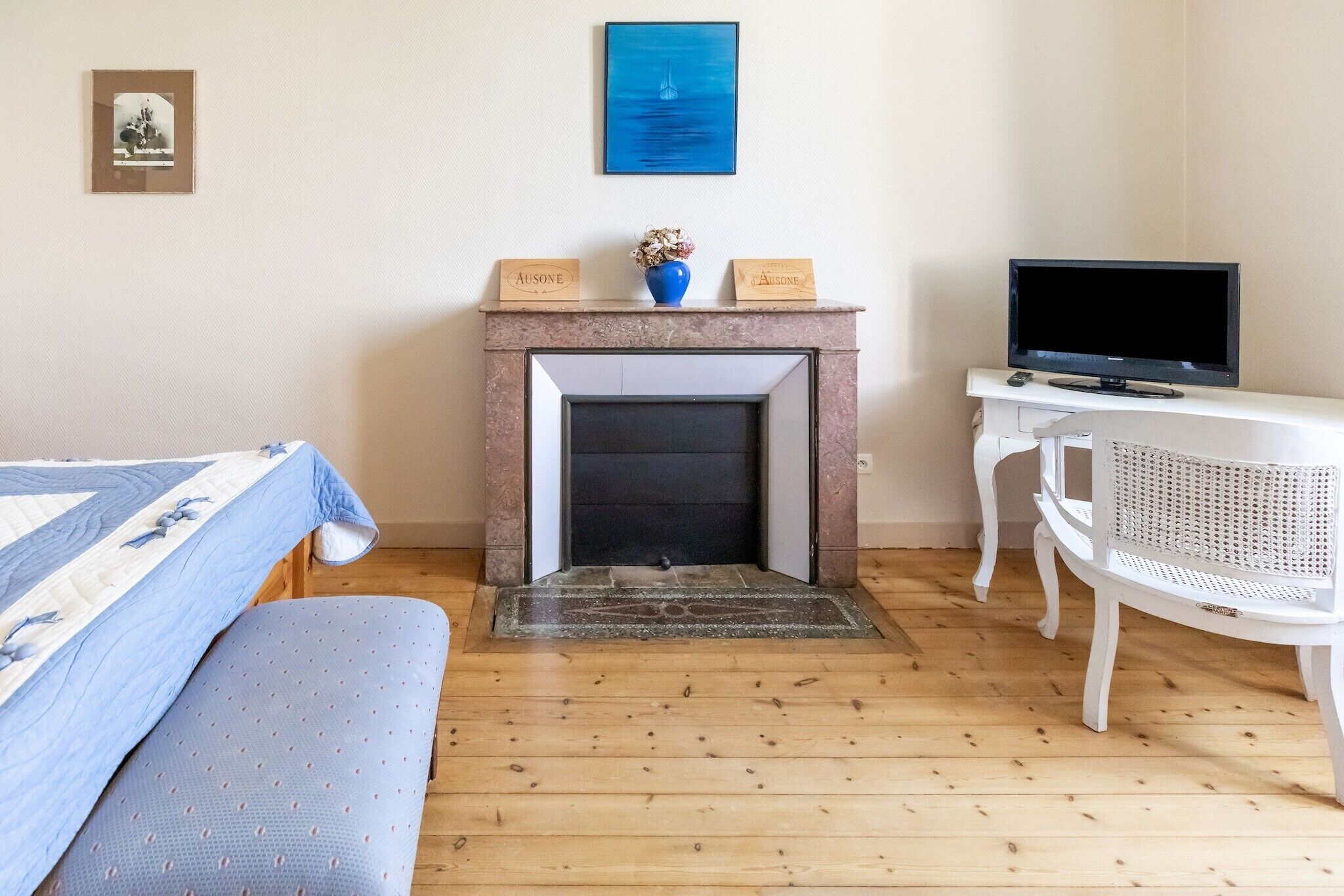 Une pièce avec une cheminée, un lit, une télévision et un fauteuil.