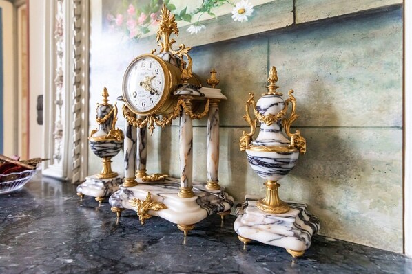Eine Marmor-Uhr mit goldenen Akzenten auf einer Marmorarbeitsplatte.