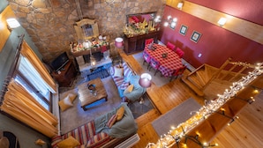 Un interior acogedor con paredes de piedra, muebles de madera y un comedor con mantel rojo.