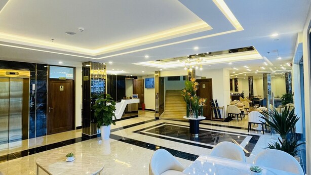 A modern hotel lobby with a spacious seating area, a reception desk, and a view of the interior dining area. - Sandals Flora Hotel (Xuan Huong - Da Lat)