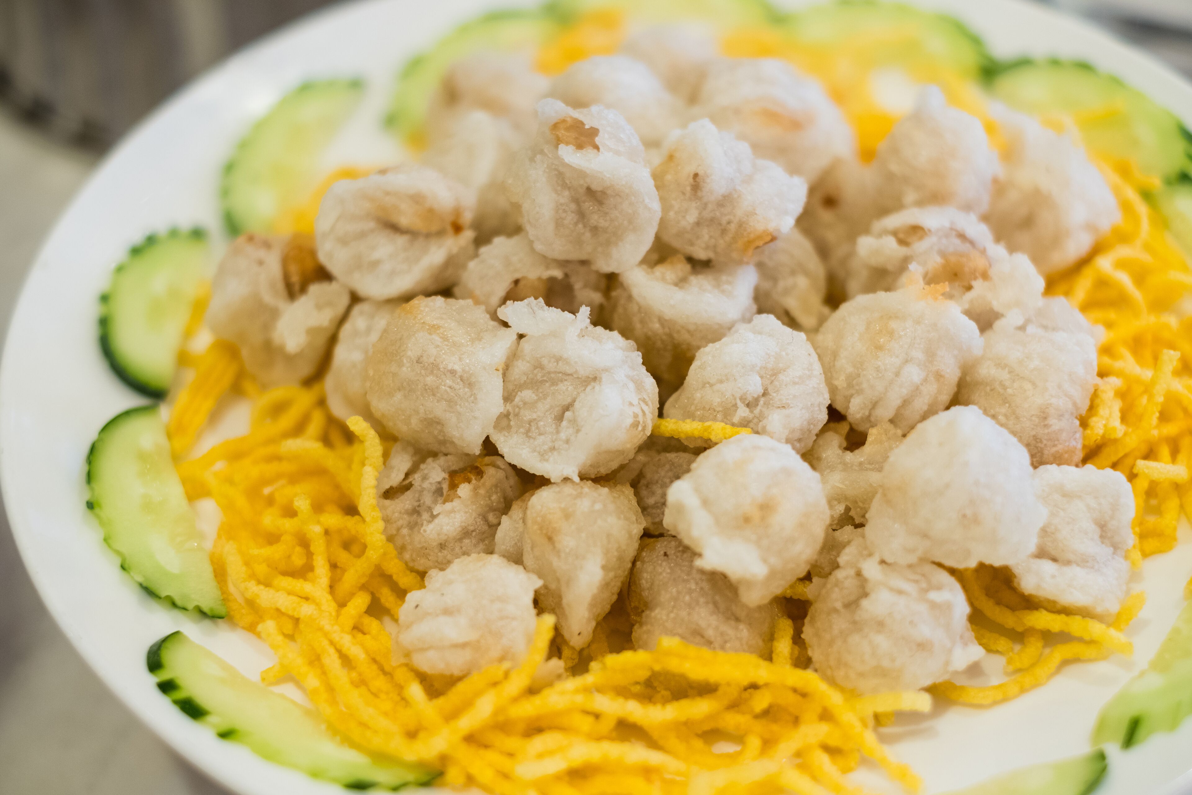A plate of food with cauliflower and shredded cheese.