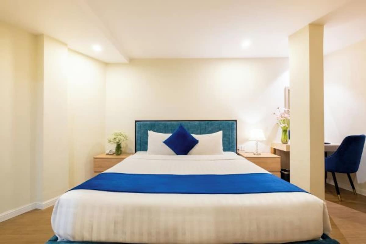 Una habitación de hotel con una cama grande, un escritorio y una silla.