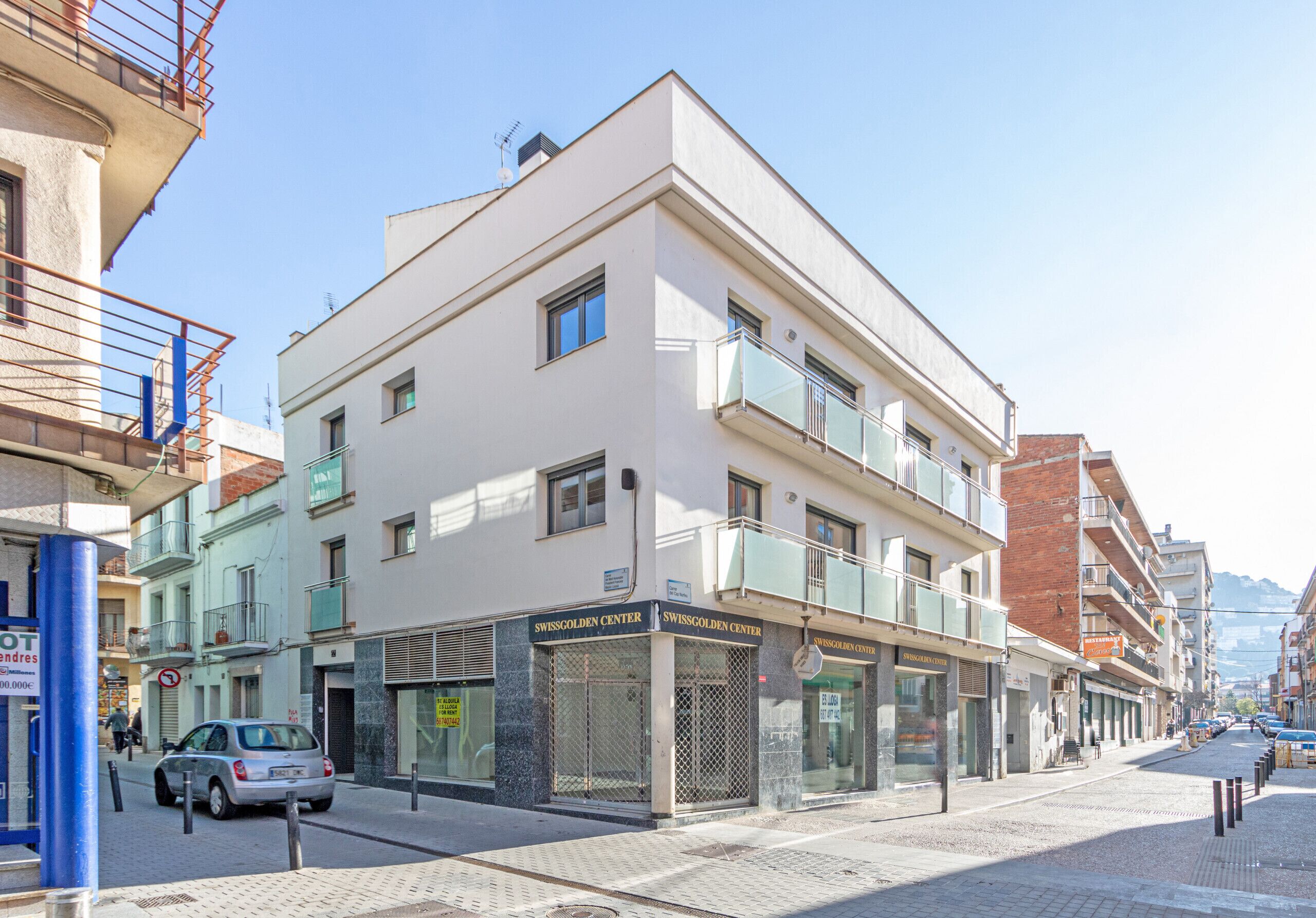 Un immeuble à plusieurs étages dont le rez-de-chaussée abrite un magasin appelé « Swissgolden Center ».