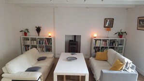 Una sala de estar moderna con dos sofás, una mesa de centro y dos estanterías llenas de libros.