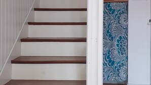 Una escalera con escalones de madera y barandillas blancas, que conduce a un piso superior.