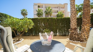A patio area with a table, chairs, and a bottle of champagne. - Apartment 'Estrella 2 3 BH' close to the Beach with Shared Pool & Wi-Fi (l'Alfàs del Pi)