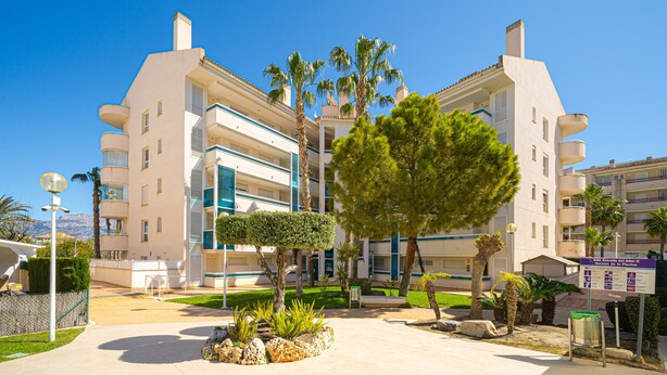 A multi-story hotel with balconies, a courtyard with trees, and a sign indicating amenities. - Apartment 'Estrella 2 3 BH' close to the Beach with Shared Pool & Wi-Fi (l'Alfàs del Pi)