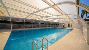 A swimming pool with a glass ceiling, metal railings, and a tiled floor. - Apartment 'Estrella 2 3 BH' close to the Beach with Shared Pool & Wi-Fi (l'Alfàs del Pi)