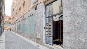 A narrow urban street with a building featuring large windows, a metal door, and a visible number '52'. - Pet-Friendly Apartament Luisa close to the Beach with Balcony & Wi-Fi (Lloret de Mar)