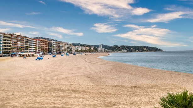 A beach with a row of buildings, a clear sky, and a calm sea. - Pet-Friendly Apartament Luisa close to the Beach with Balcony & Wi-Fi (Lloret de Mar)