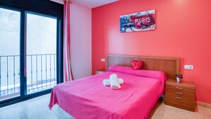 A room with a bed, a nightstand, a window with a view, and a poster on the wall. - Apartment Yaco 2 near the beach with sea views and Wi-Fi (Lloret de Mar)