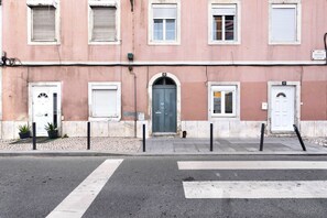 A building with multiple doors and windows, a crosswalk, and bollards. - Apartment 'LxFactory Terrace Lisbon Loft' with Terrace & Wi-Fi (Lisboa)