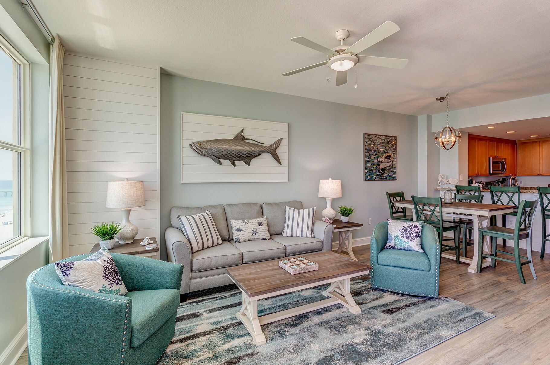 A living room with a sofa, two armchairs, a coffee table, and a dining area with a table and chairs.