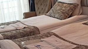 Habitación de hotel con cama, una silla, equipo de aire acondicionado y una lámpara fijada a la pared.
