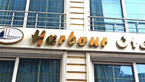 Un letrero de hotel con el nombre 'Harbour Hotel' y un logotipo que muestra un velero.