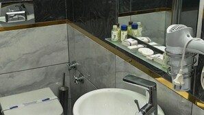 Un baño moderno con un lavabo blanco, un inodoro y un espejo.