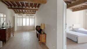 Ein Zimmer mit Holzboden, einem Bett, einem Schminktisch und einer Lampe.