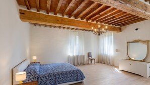 Ein Schlafzimmer mit Bett, Nachttischen, einem Schminktisch und einem großen Spiegel.