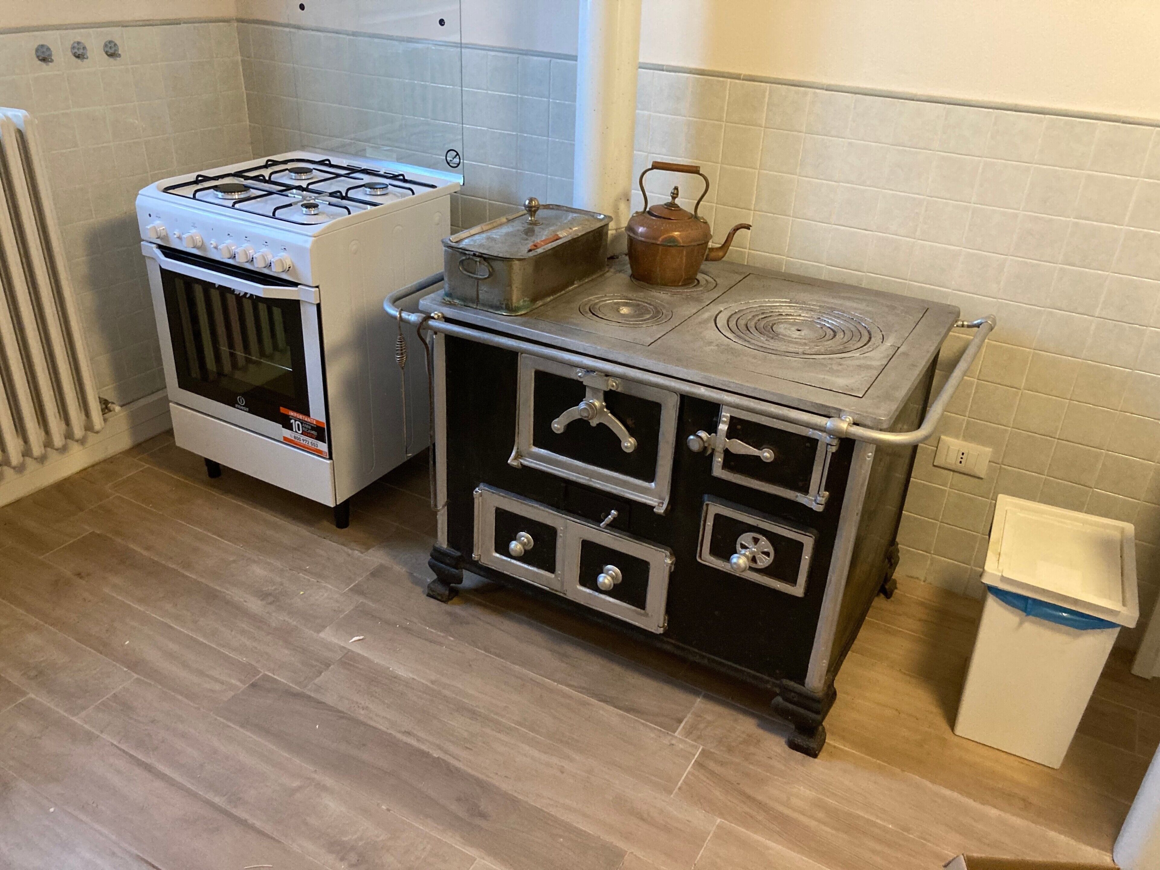 Cuina amb forns de gas, forn, batedora i paperera.