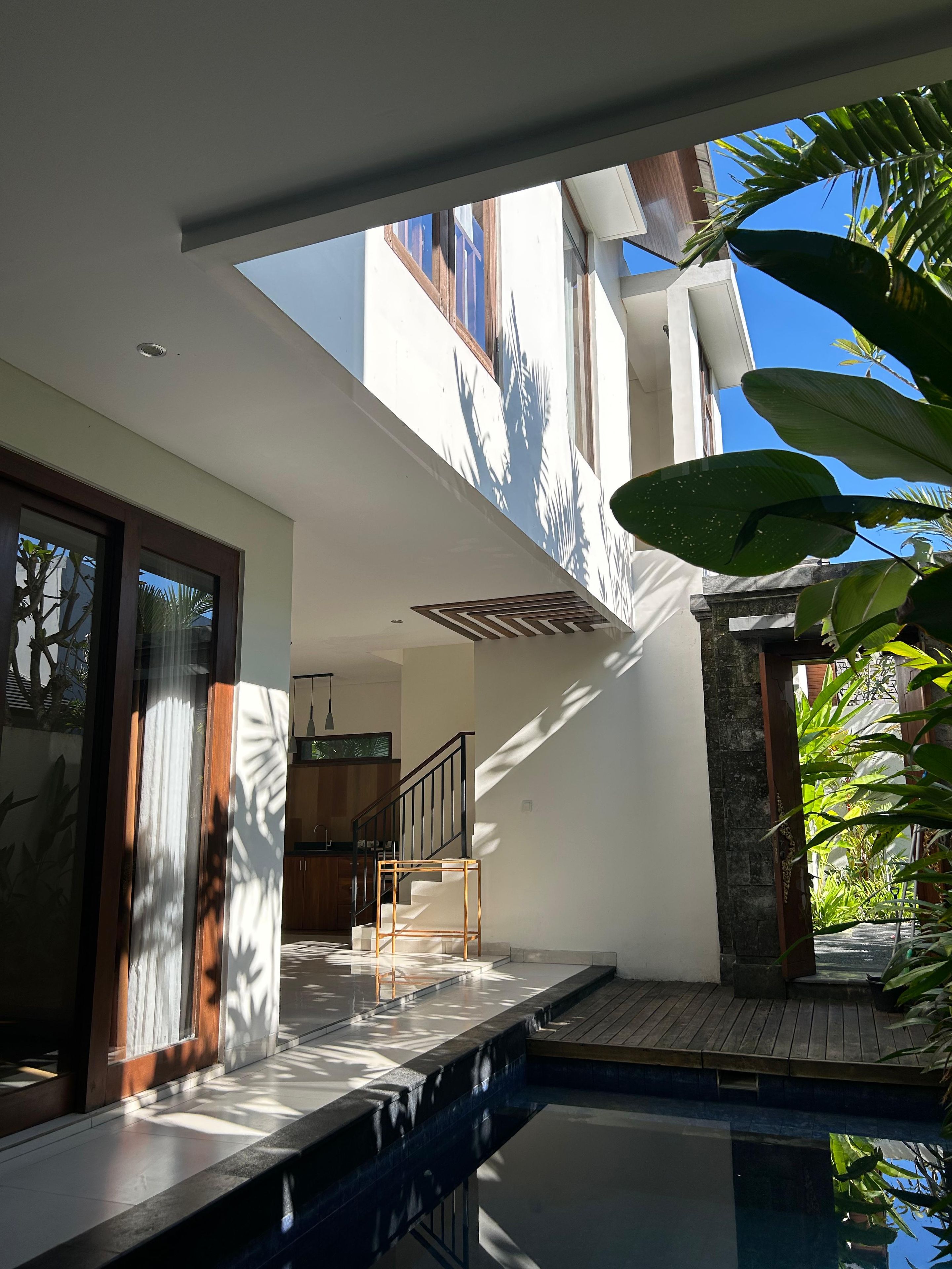 Une maison moderne dotée d’une piscine, d’un escalier et offrant une vue sur le ciel.