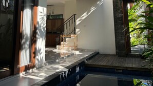 A modern house with a swimming pool, a staircase, and a view of the sky. - The Calna Villa (Kuta)