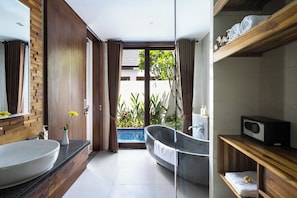 A modern bathroom with a large sink, a freestanding bathtub, and a wooden vanity. - The Calna Villa (Kuta)