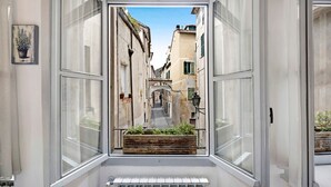 A narrow street view through a window with a radiator below. - Pet-Friendly Apartment Bilocale Merlino with Mountain View & Wi-Fi (Finale Ligure)