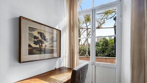 A room with a wooden bench, a framed picture on the wall, and a window with curtains. - Pet-Friendly Apartment Quadrilocale Camelot with Mountain View, Balcony & Wi-Fi (Finale Ligure)