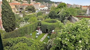 Um jardim com gramado, área de estar e estrutura de pedra.