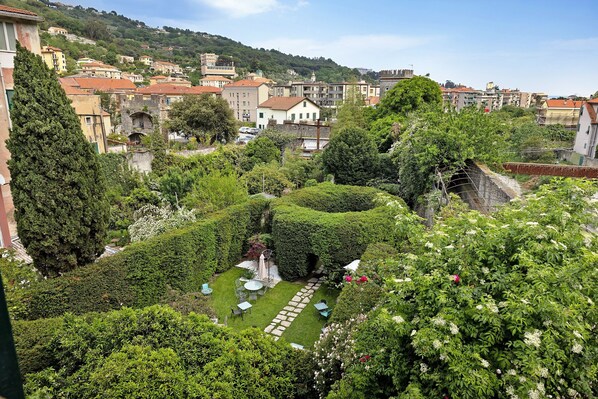 A garden with a lawn, seating area, and a stone structure.