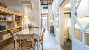 A dining area with a wooden table, chairs, and a lamp. There is a window with a view of the outside. - Studio "Radicondoli" with Balcony & Wi-Fi (Radicondoli Siena)