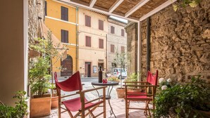 Une terrasse avec deux chaises rouges, une table et des plantes en pot.