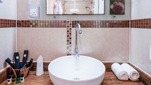 A bathroom with a round sink, a mirror, and a towel rack. - RIJ HULHUMALE (Hulhumalé)