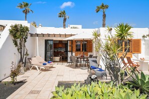 Une terrasse avec des meubles d’extérieur, un coin repas et une vue sur le ciel.