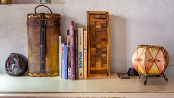 Une étagère avec des livres, un appareil photo, un tambour et une boîte en bois.