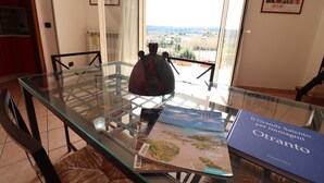 Una mesa con superficie de vidrio, un libro titulado 'Il Grande Salento per immagini' y un mapa.