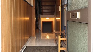 A hallway with wooden paneling, a staircase, and a door with a textured panel.