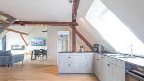 A modern kitchen with a skylight, wooden beams, and a dining area with a sofa and chairs. - Vacation home Arlau Schleuse in the Hattstedtermarsch for up to 4 people (Hattstedtermarsch)