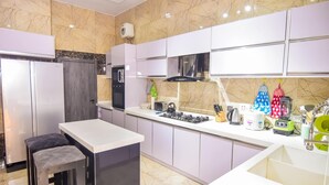 Una cocina moderna con encimeras de mármol, estufa a gas y horno empotrado.