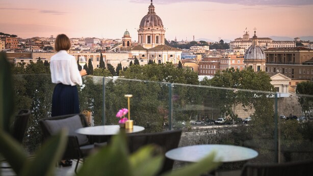 A terrace with tables and chairs overlooking a cityscape with historical buildings. - The First Musica - Preferred Hotels & Resorts (Rome)
