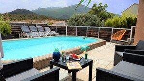 A swimming pool with lounge chairs and a table with drinks and a menu.